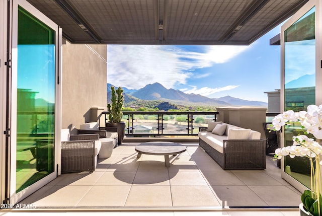 view of patio / terrace with an outdoor living space, a mountain view, and a balcony