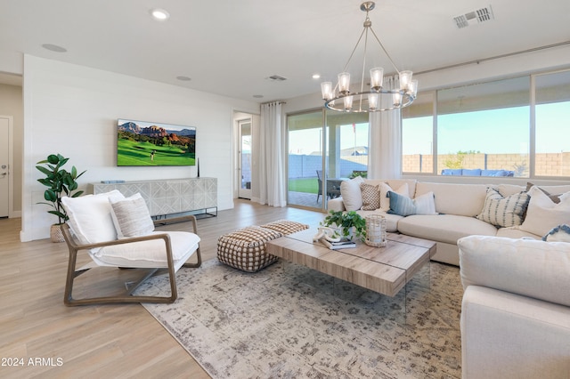 living room featuring a chandelier and light wood-type flooring