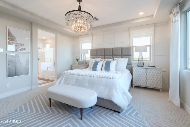 bedroom with ensuite bath, light carpet, and an inviting chandelier