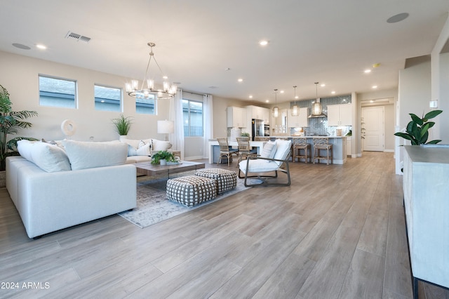 living room with a chandelier and light hardwood / wood-style floors