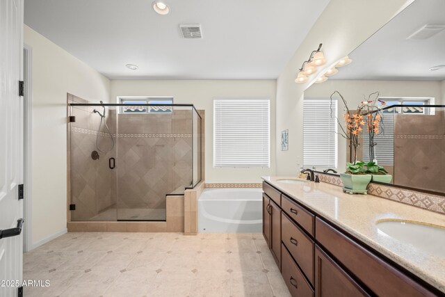 2163 N 164th Dr, Goodyear, AZ 85395 - full bathroom featuring healthy amount of natural light, a garden tub, double vanity, a stall shower, and recessed lighting