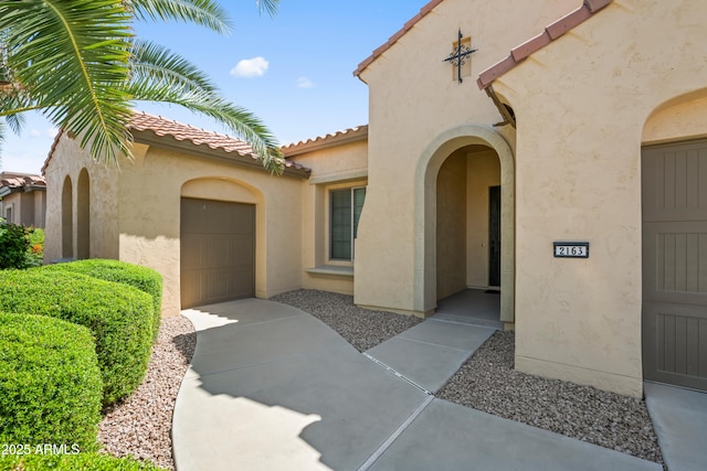 2163 N 164th Dr, Goodyear, AZ 85395 - doorway to property featuring stucco siding, an attached garage, concrete driveway, and a tiled roof
