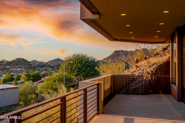 balcony at dusk featuring a mountain view