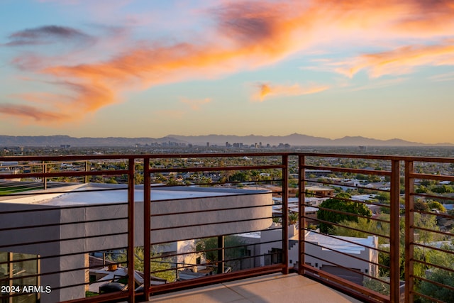 balcony at dusk featuring a mountain view