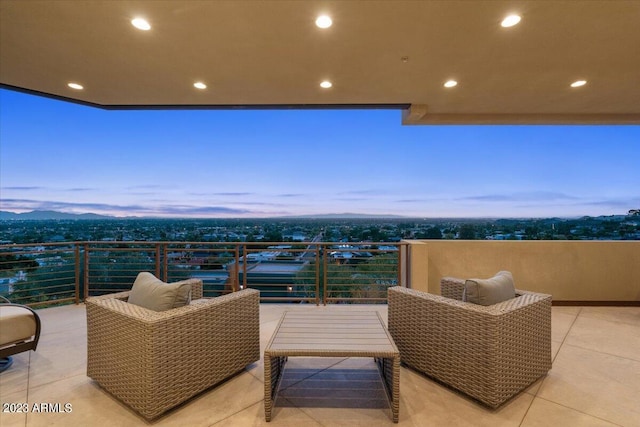 patio terrace at dusk with outdoor lounge area and a balcony