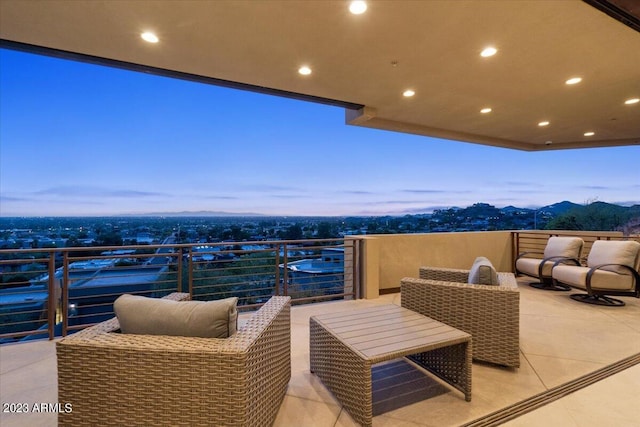 patio terrace at dusk with an outdoor living space and a balcony