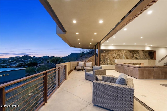 balcony at dusk featuring a mountain view and outdoor lounge area