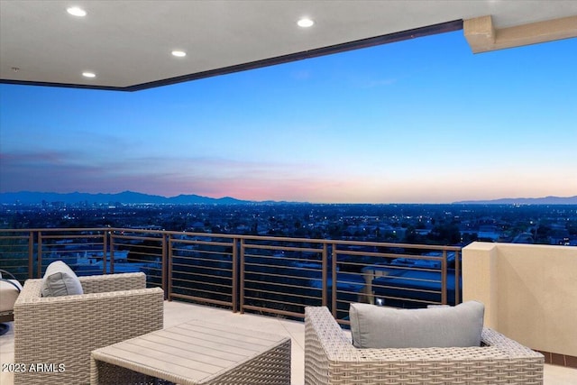 balcony at dusk featuring a mountain view