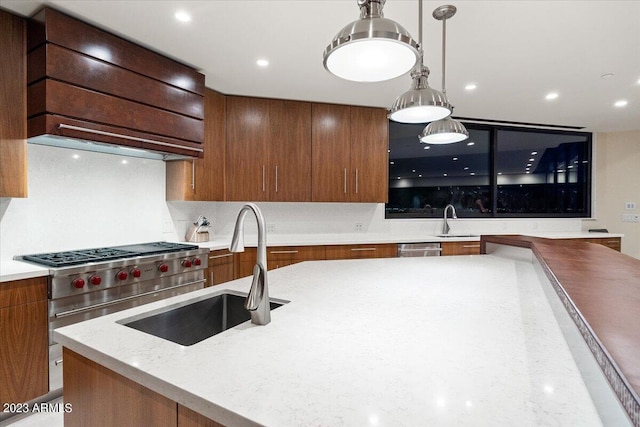 kitchen featuring pendant lighting, custom range hood, sink, and backsplash