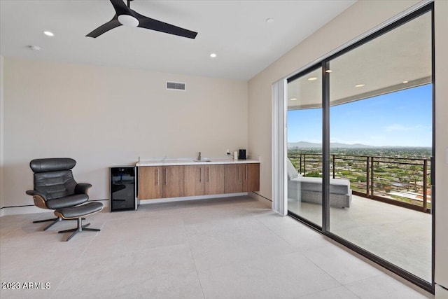 living area with ceiling fan and wine cooler