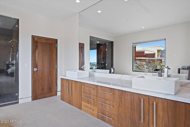 bathroom featuring a shower with shower door and vanity