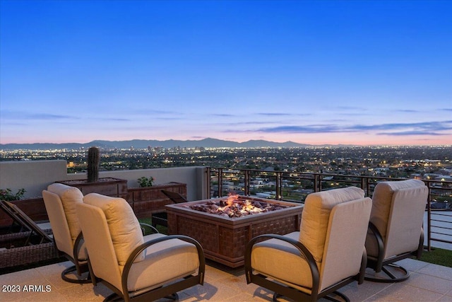 patio terrace at dusk with an outdoor fire pit and a mountain view