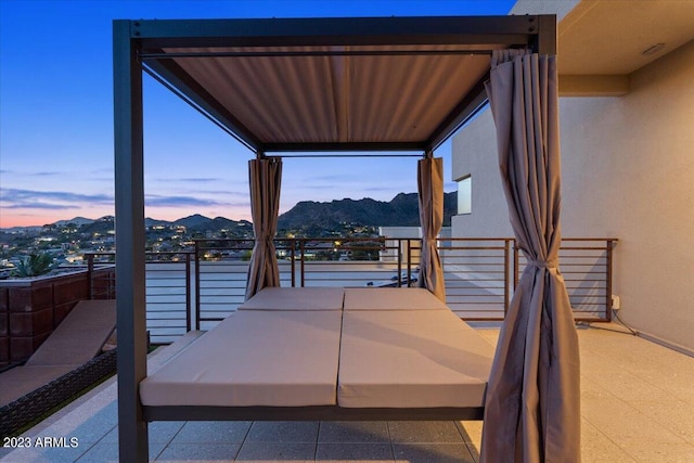 balcony at dusk featuring a mountain view