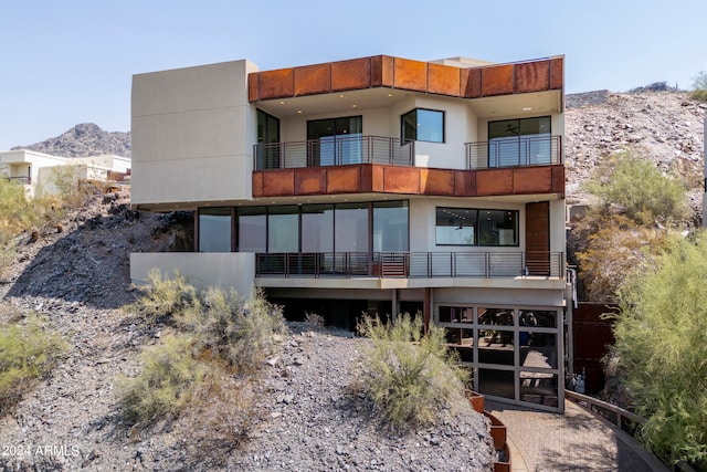 rear view of house featuring a mountain view and a balcony