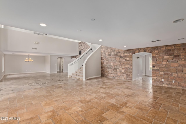 unfurnished living room featuring a chandelier