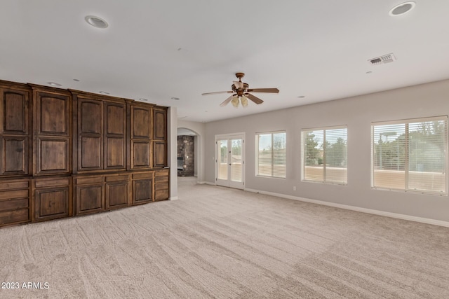 unfurnished living room with ceiling fan and light colored carpet