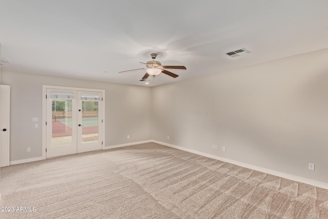 empty room featuring light carpet, french doors, and ceiling fan