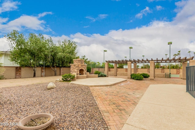 view of yard featuring an outdoor stone fireplace and a patio area