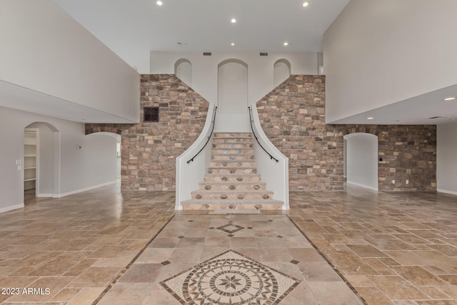 unfurnished living room featuring a high ceiling