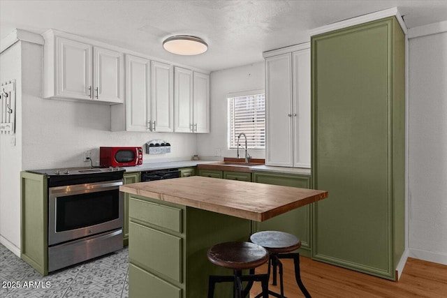 kitchen featuring green cabinetry, wooden counters, stainless steel electric stove, a sink, and white cabinetry