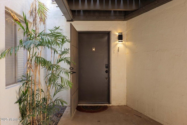 entrance to property featuring stucco siding