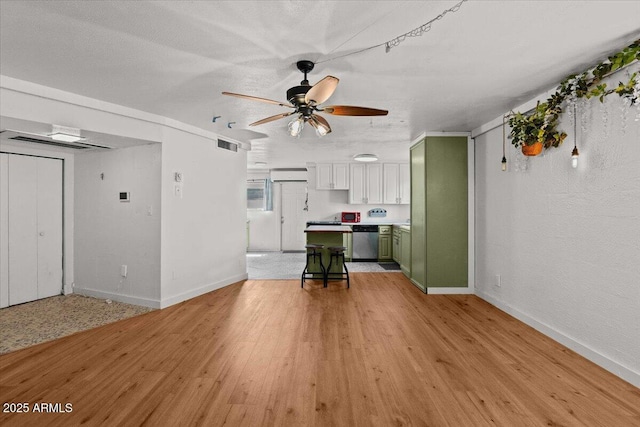 unfurnished living room with light wood-type flooring, baseboards, and ceiling fan