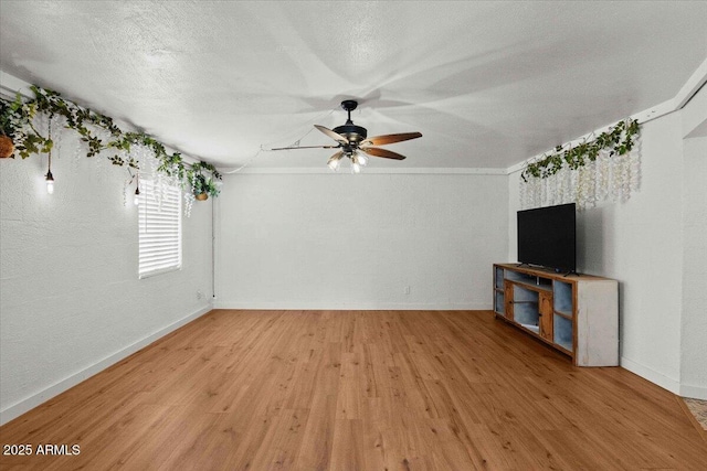 unfurnished living room with light wood-style floors, a ceiling fan, baseboards, and a textured ceiling