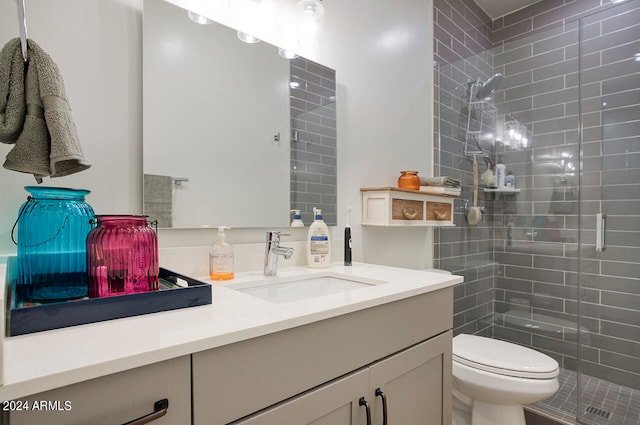 bathroom with vanity, toilet, and a shower with shower door