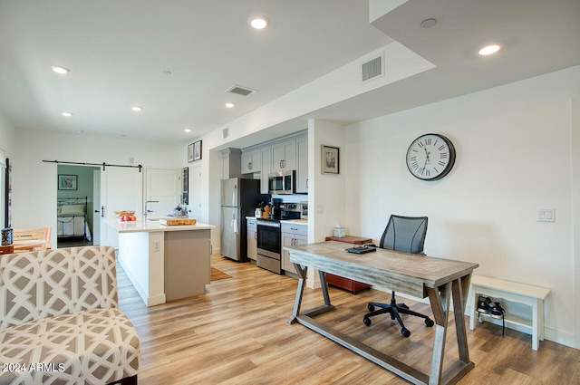 office area featuring light hardwood / wood-style flooring and a barn door