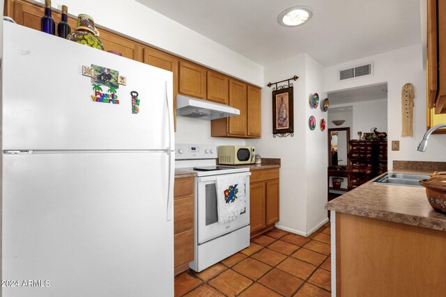 kitchen featuring light tile patterned flooring, sink, and white appliances