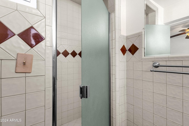 bathroom featuring ceiling fan and a shower with door