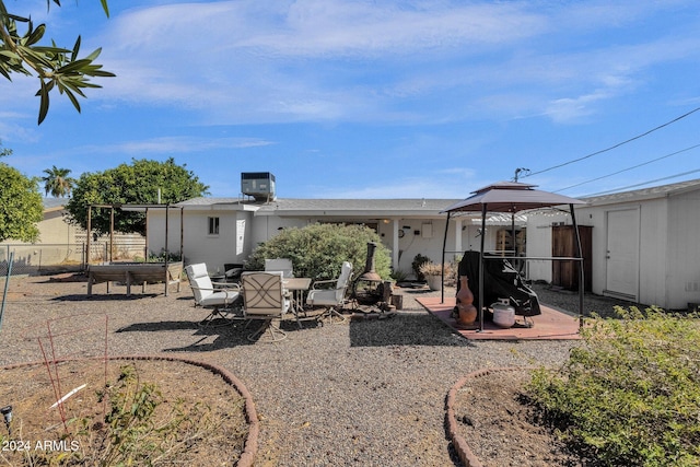 back of house with a storage shed, a patio area, fence, and an outdoor structure