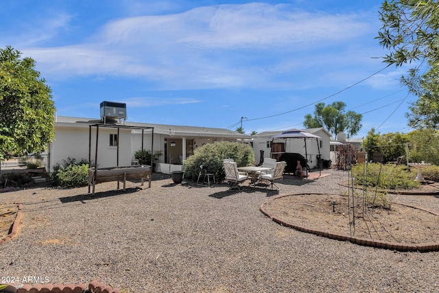 rear view of property with central AC unit and a patio