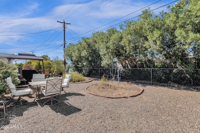 view of yard with a gazebo, outdoor dining area, a patio, and fence