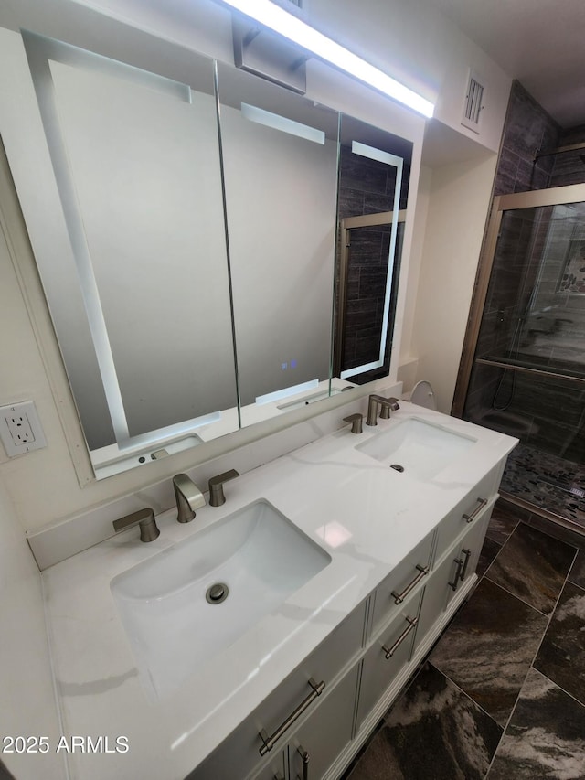 bathroom featuring tiled shower and vanity