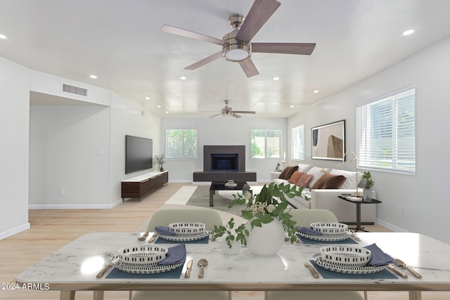 living area with light wood-type flooring, visible vents, baseboards, and recessed lighting