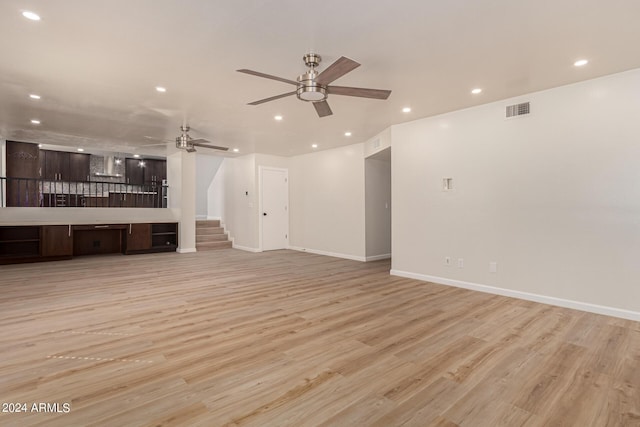 unfurnished living room featuring recessed lighting, visible vents, baseboards, stairway, and light wood-type flooring