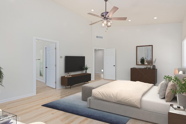 bedroom featuring light wood-style flooring, recessed lighting, a towering ceiling, baseboards, and visible vents