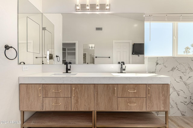 full bath featuring double vanity, a sink, and visible vents