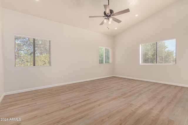 unfurnished room with a ceiling fan, baseboards, vaulted ceiling, and light wood finished floors