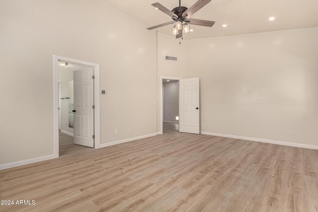 unfurnished bedroom featuring high vaulted ceiling, light wood-type flooring, visible vents, and baseboards