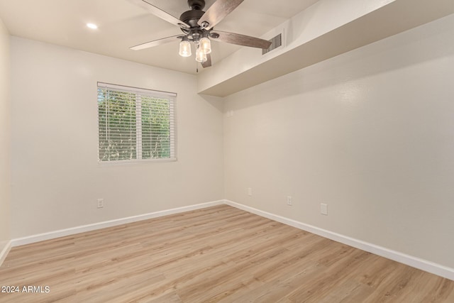 empty room featuring light wood finished floors, visible vents, baseboards, and ceiling fan