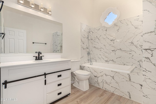 bathroom with a combined bath / shower with marble appearance, vanity, toilet, and wood finished floors