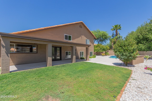 back of property with a fenced backyard, a lawn, a patio, and stucco siding