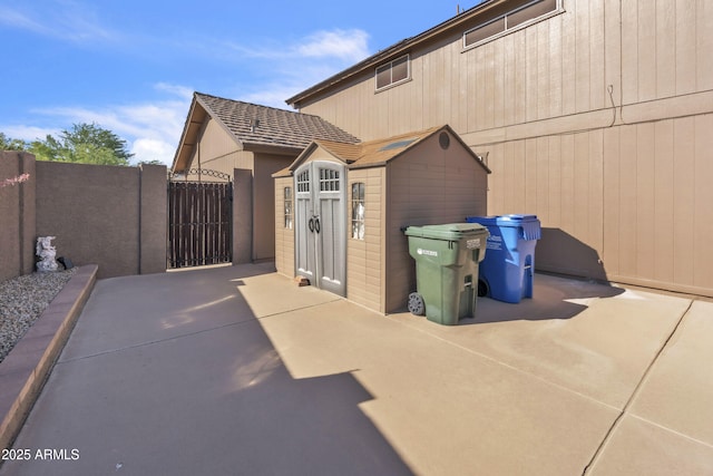 4547 E Buist Ave, Phoenix, AZ 85044 - view of home's exterior featuring a storage shed, a patio, and a gate
