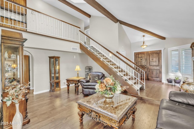 4547 E Buist Ave, Phoenix, AZ 85044 - living room with stairway, beamed ceiling, wood finished floors, arched walkways, and high vaulted ceiling