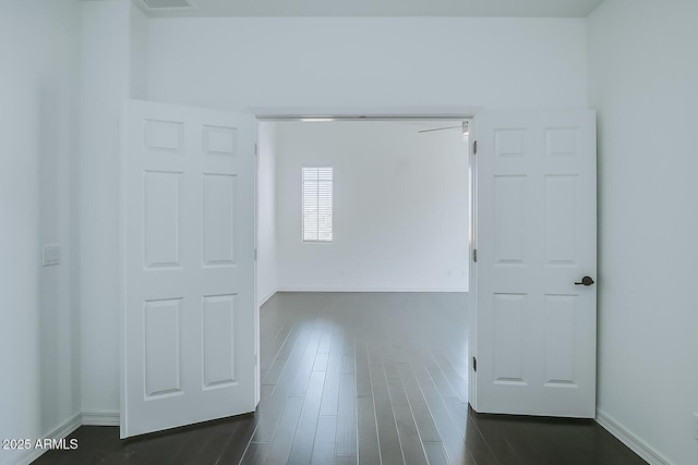 empty room featuring dark wood-style flooring and baseboards