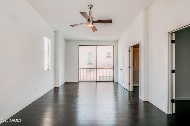 empty room featuring dark wood-style floors, baseboards, and a ceiling fan