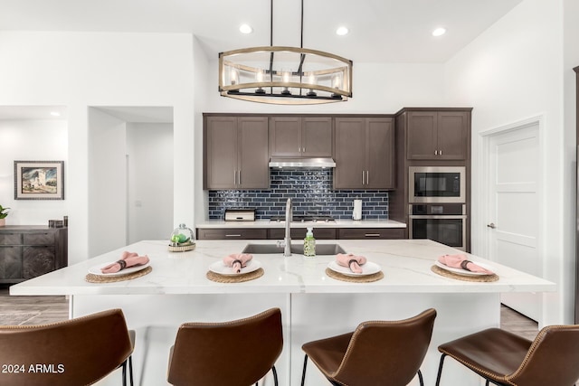 kitchen featuring a center island with sink, pendant lighting, and appliances with stainless steel finishes