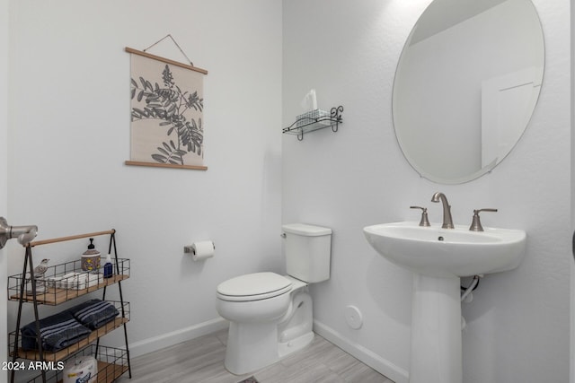 bathroom with wood-type flooring and toilet